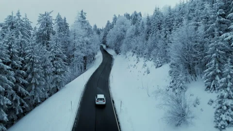 Epic view of car drive on empty road in snowy forest wonderland. Stock Footage 229648600
