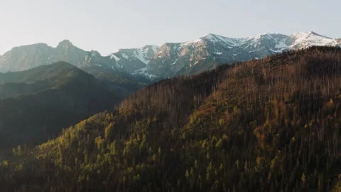 Epic view high mountain peaks covered with snow lit with warm sunrise light Stock Footage 243225831