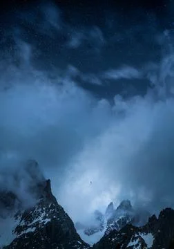 An epic view of paraglider in between high mountains and below stars Stock Photos