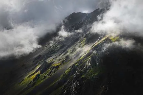 The epic view of the rocky slope in the sunset and low clouds. Elbrus North Stock Photos