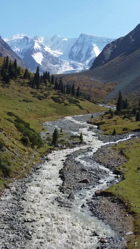 Epic view of snow-capped mountain peaks and winding river in alpine valley Stock Footage 336689136