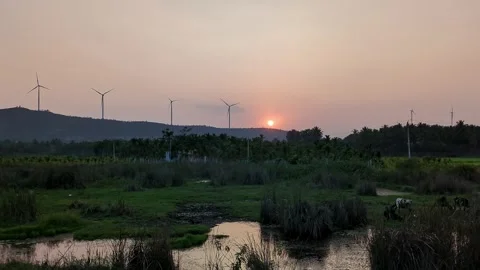 An epic view of a summer sunset over mountains with wind turbines slowly ro.. Stock Footage 313381921