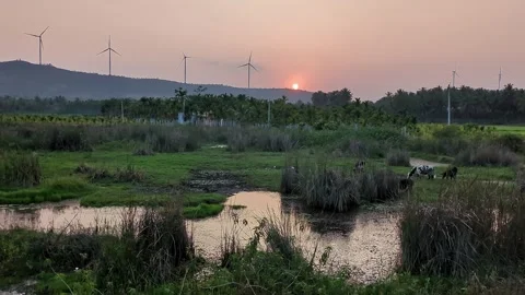 An epic view of a summer sunset over mountains with wind turbines slowly ro.. Stock Footage 313381935