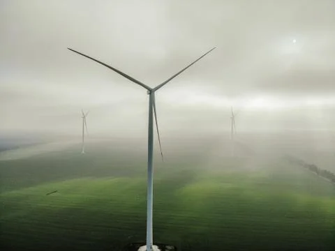 Epic view of a windmill amid the rays of the sun from under the clouds Stock Photos