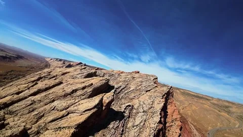 Epic wide angle aerial shot of a deep canyon with a winding road and blue sky Vídeos de archivo 331769525
