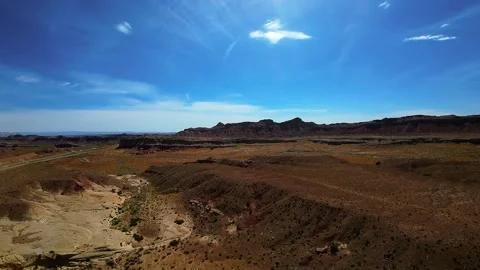 Epic wide angle shot of a dry barren plain, red rock buttes and clear blue sky Vídeos de archivo 331920079