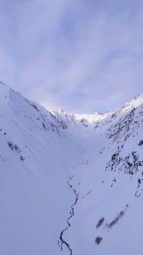 “Epic winter drone footage featuring dramatic valleys, snowy landscapes, and unt Stock Footage 323215692