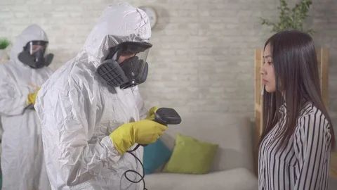 Epidemiologists in protective suits measure the temperature of asian girls close Stock Footage 125247259