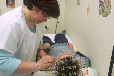  Epilepsy, eeg Hospital. A function testing technician positions electrode... Foto stock