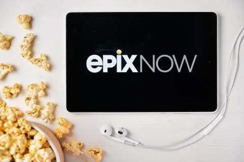 Epixnow on the screen of the tablet with popcorn box and Apple earphones on the Stock Photos