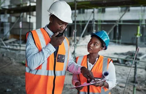 Equal hands forge firm foundations. a young man using a walkie talkie while Stock Photos