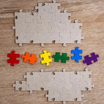 Equality concept: LGBT pride flag built from a puzzle, among gray puzzles sho Stock Photos