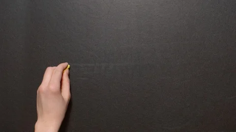 Equality. A left female hand writes the word by orange chalk on a black board Stock Footage 127292101