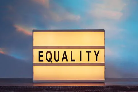 Equality text on a lightbox on a colorful background similar to the sunset sky Stock Photos