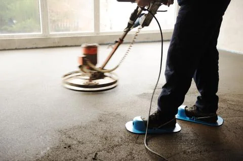 Equating and leveling fresh cement for the floor, by one worker Stock Photos