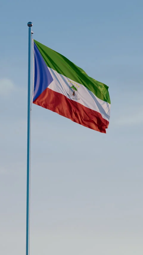 Equatorial Guinea, Malabo: Cinematic Vertical Waving National Flag Against Blue  Stock Footage 321809420