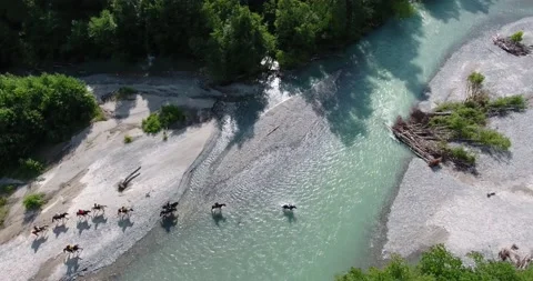 Equestrian group cross a mountain river - drone shot Stock Footage 170598823