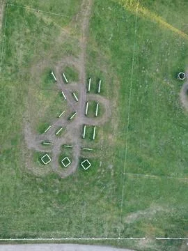 Equestrian jumping obstacles arranged across a grassy training arena Stock Photos
