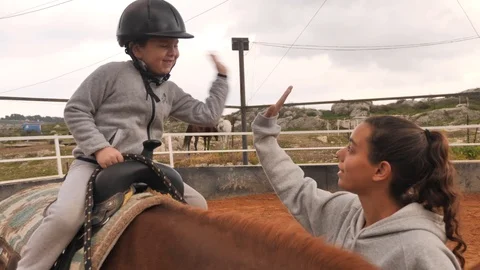 Equine-assisted therapy high five on horse Stock Footage 103445607