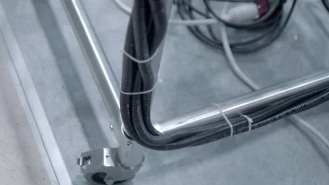 The equipment is connected to several wires, each in its own flexible conduit Stock Footage 340463922