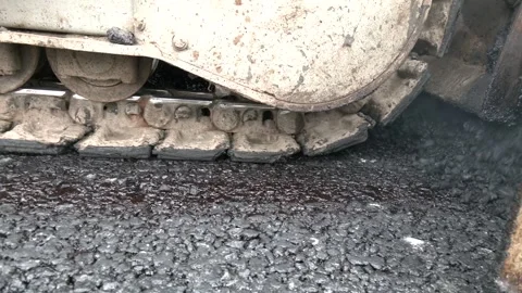 The equipment is spreading materials on the road to prepare 動画素材 330351047