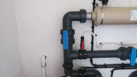 Equipment in a swimming pool technical room with filter, plastic pipes, and valv Stock Footage 312019023
