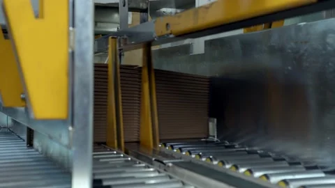 Equipment ties stack of folded cardboard boxes at plant Stock Footage 144975672