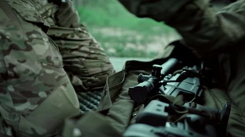 Equipped soldier pulls out a sniper rifle. War. Military operation. Stock Footage 107491668
