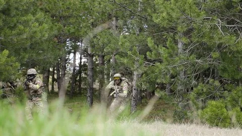 Equipped soldiers moving through forest with rifle ready to shoot. Stock Footage 127753601