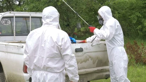 Equipped workers taking pulverizer from car in field Stock Footage 71542361
