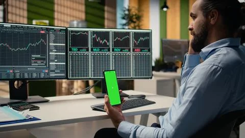 Equity analyst using green screen smartphone to reviews quarterly earnings Stock Photos