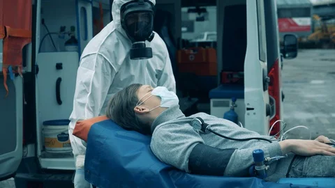 ER doctors take a patient into an ambulance car. Coronavirus epidemic, covid-19 Stock Footage