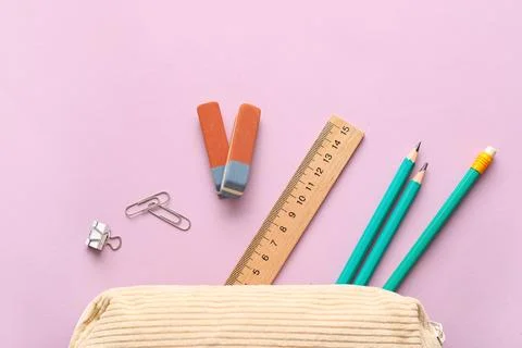 Erasers with pencil case and different stationery on lilac background Stock Photos