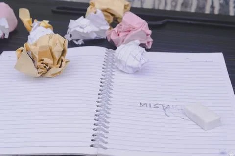 Erasing Mistake on notepad. Learning, wrong, blooper, regret sayings backgrou Stock Photos