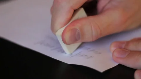 Erasing written from a paper with rubber Stock Footage 70515797
