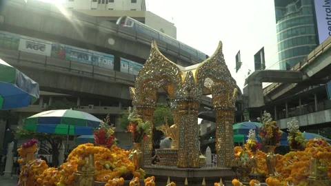 Erawan Shrine Bangkok - Pan - right to left - Train passing Stock Footage