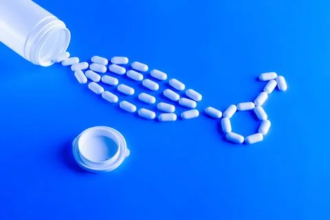 Erectile dysfunction therapy medical concept. Pills are poured out of a bottle Stock Photos