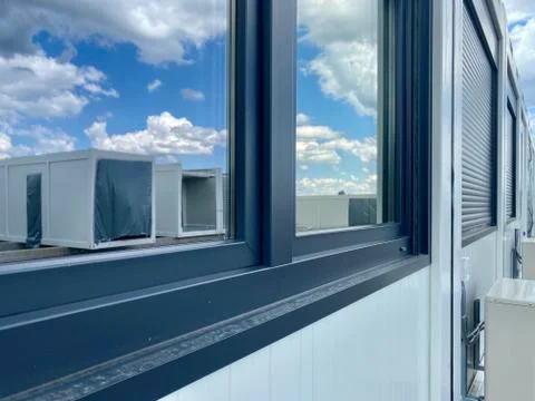 Erection of new office containers in construction site against great blue sky Stock Photos