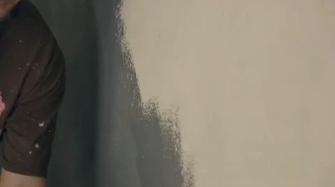 Erector paints wall in gray with help of special roller Stock Footage 66177045