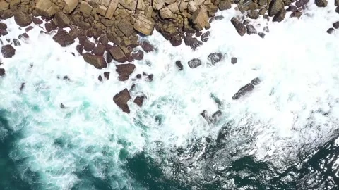 Erial top down view shoot rocks water coast splash water sea dangerous power nat Stock Footage 225659874