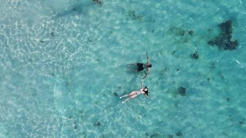 Erial view of two people floating in crystal-clear turquoise water Stock Photos
