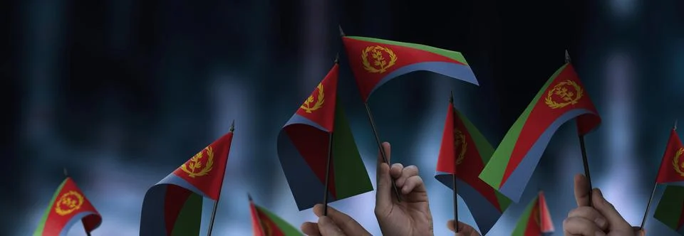 Eritrea flags in their hands on a blurred urban background Stock Photos