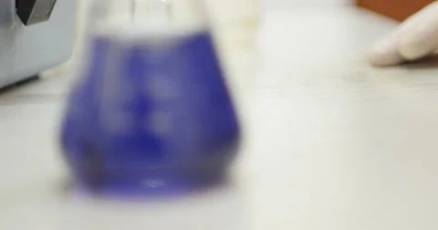 An Erlenmeyer flask being zoomed in with some blue content in it Video stock 50927939
