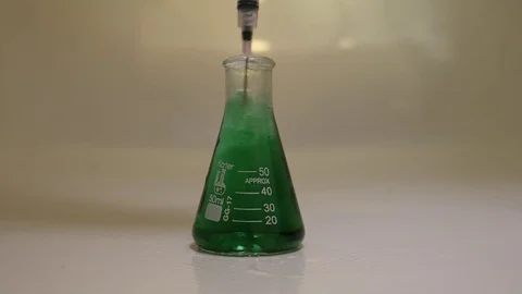 Erlenmeyer flask full of water infused with green dye 動画素材 84292398