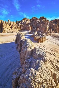 Eroded Clay Formations and Desert Terrain under Blue Sky in Cathedral Gorge.. 写真素材