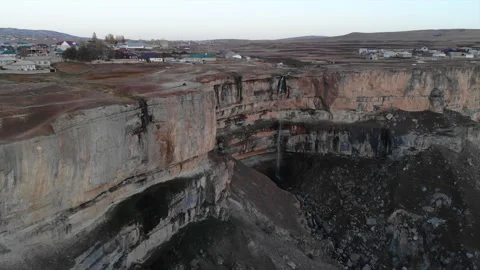 Eroded Cliff Edge With Layered Rocks Overseeing Rocky Basin Dotted With Isolated Stock Footage 324054726