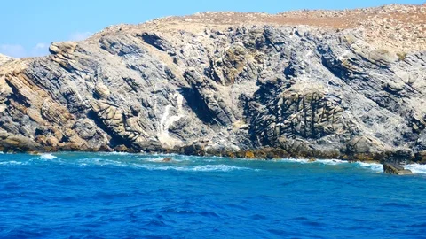 Eroded cliffs and rocks at steep coastline with blue sea, view from a boat. 動画素材 118189336