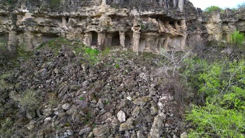 Eroded cliffside with natural stone columns and small caves, part of the Pobiti Stock Footage 307590062