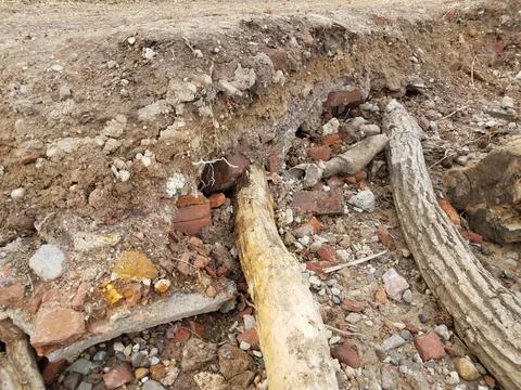 Eroded dirt path with bricks and masonry underneath 스톡 사진