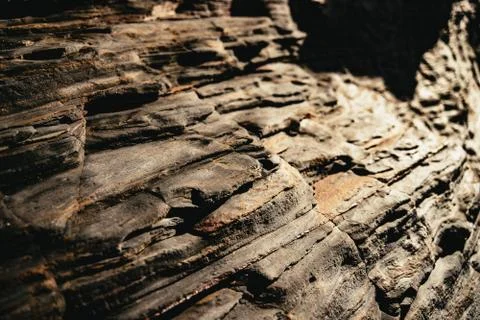 Eroded exposed layered rock strata on a beach Stock Photos